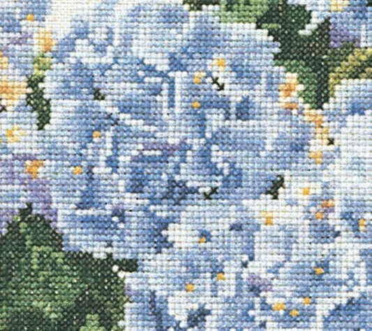 Close-up of a cross-stitched pattern with blue flowers and green leaves.