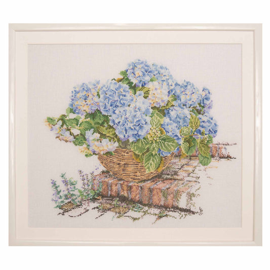 Cross-stitched design of a basket with blue and white hydrangeas on a white background
