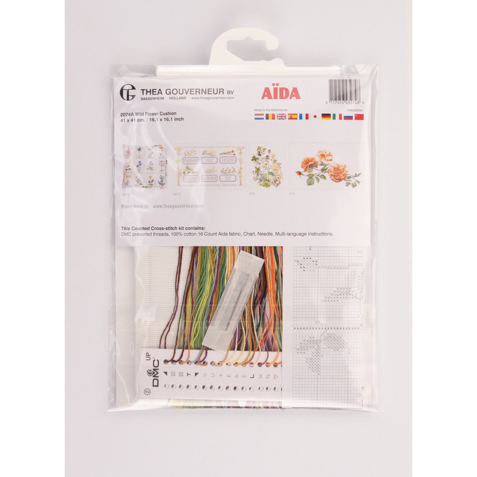 Packaged cross stitch kit with Aida needlework fabric and embroidery threads on a white background