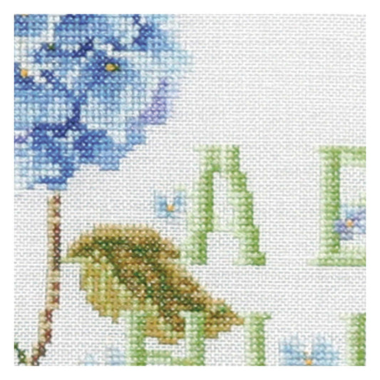 Cross-stitched design of flowers, and grass on fabric