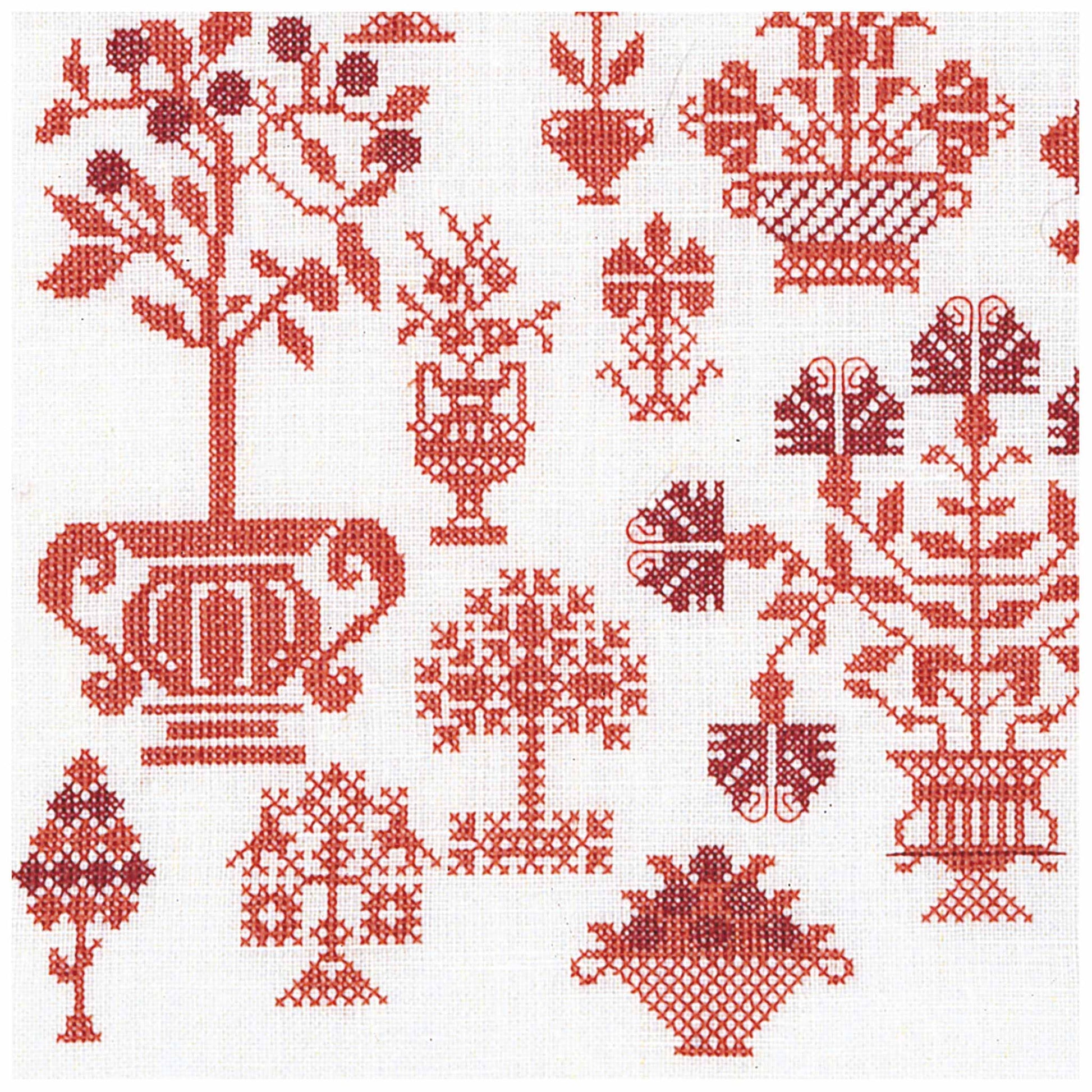 Cross stitch  pattern with red floral and geometric designs on a white background sample