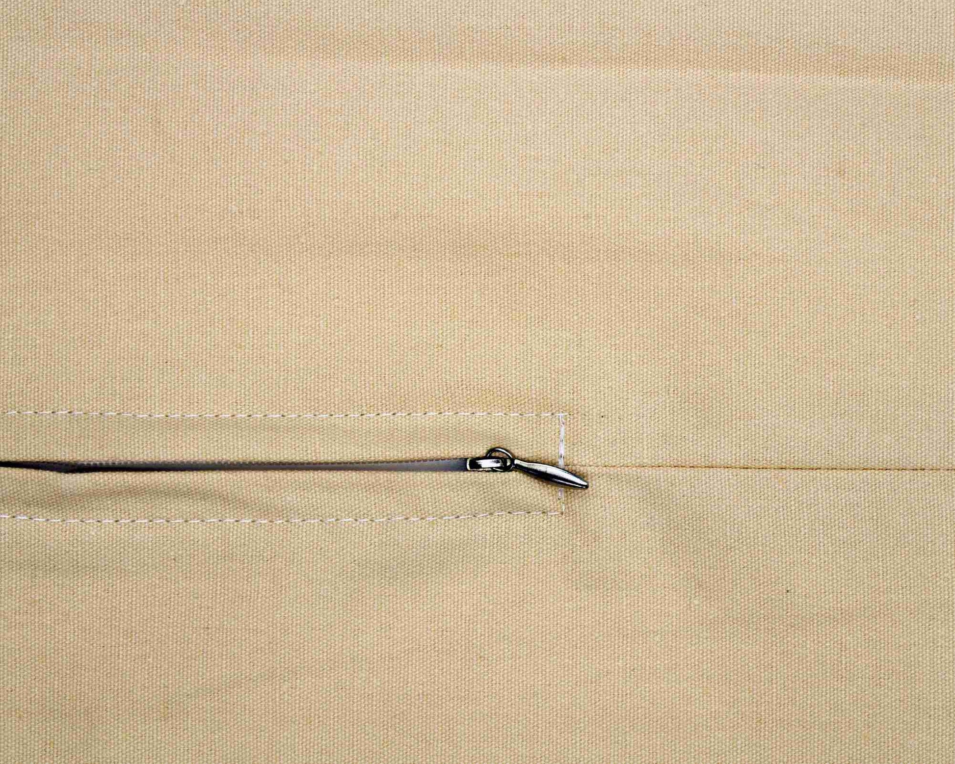 Close-up of a beige fabric with a zipper pull