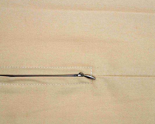 Close-up of a beige fabric with a zipper pull