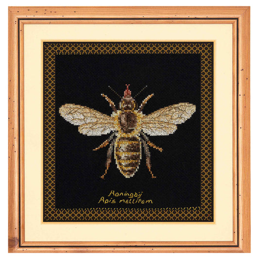 Framed cross-stitched bee on a black background with honeycomb pattern