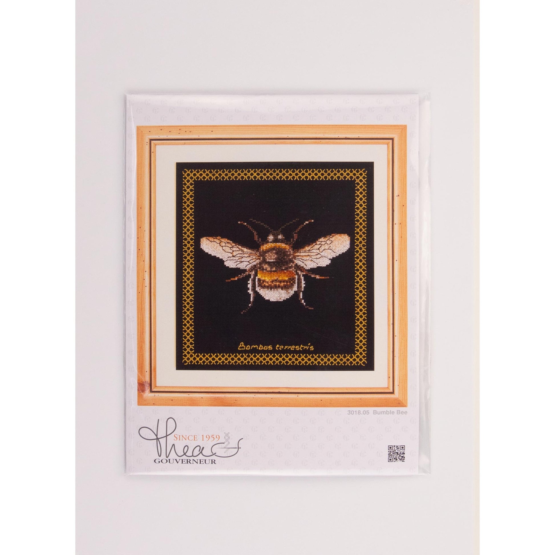 Framed cross-stitched Bumble Bee package with a decorative border on a white background