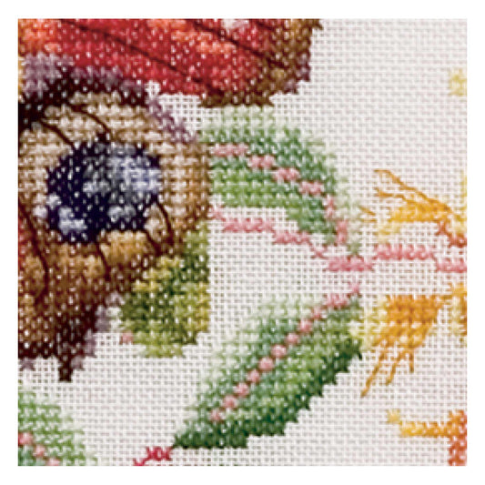 Close-up of a cross-stitched piece with colorful leaves and flowers on a white background