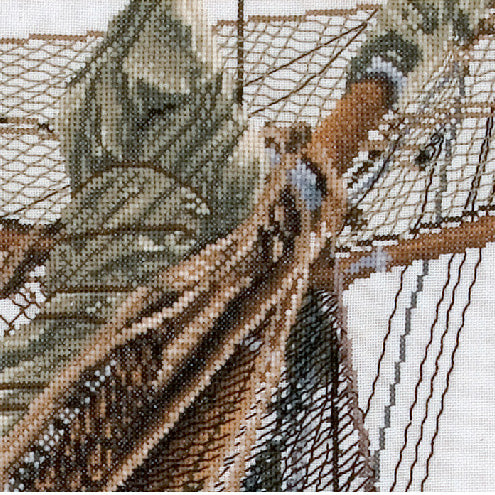Close-up of a cross-stitched boat with detailed patterns on fabric.