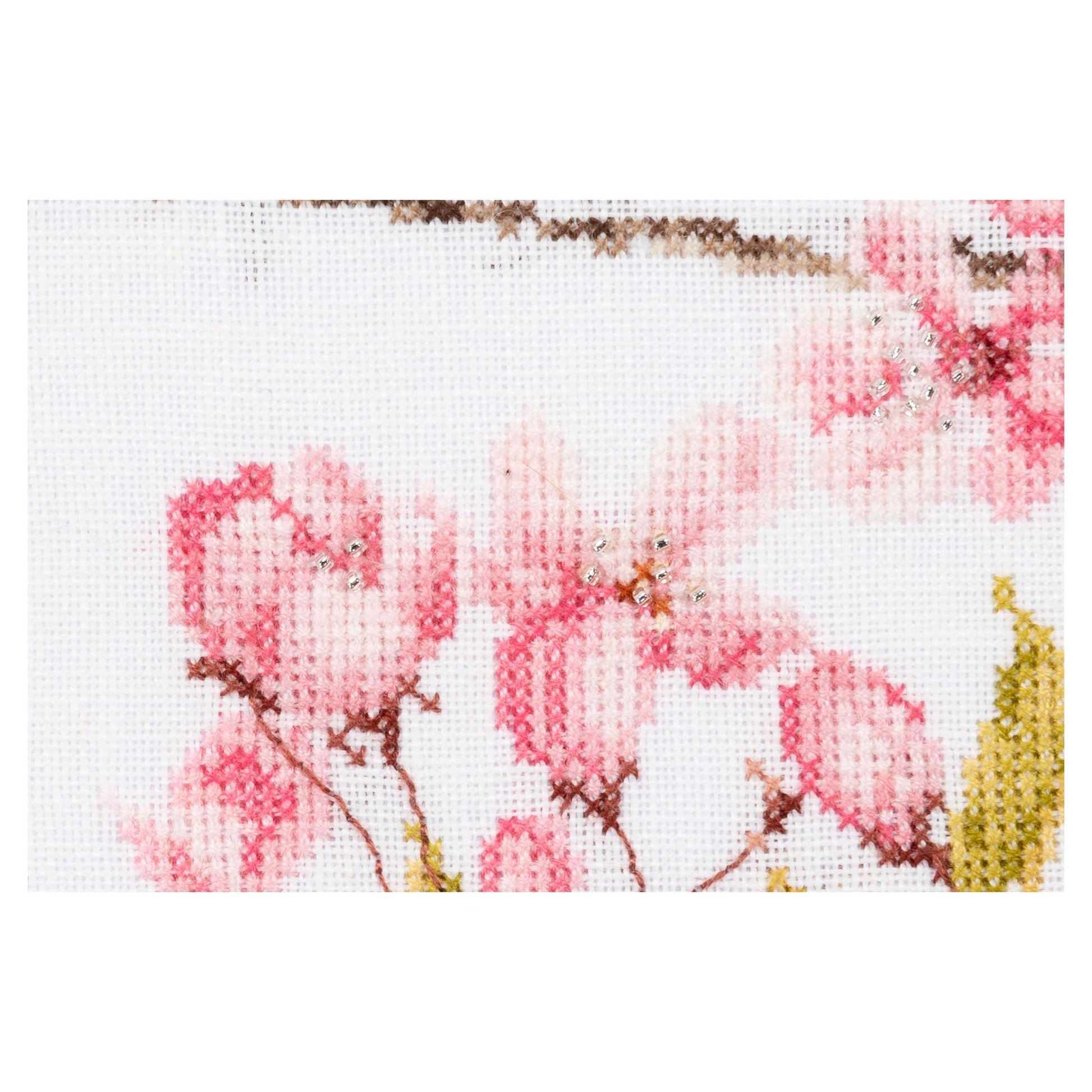 Cross-stitched pink flowers on a white background close up