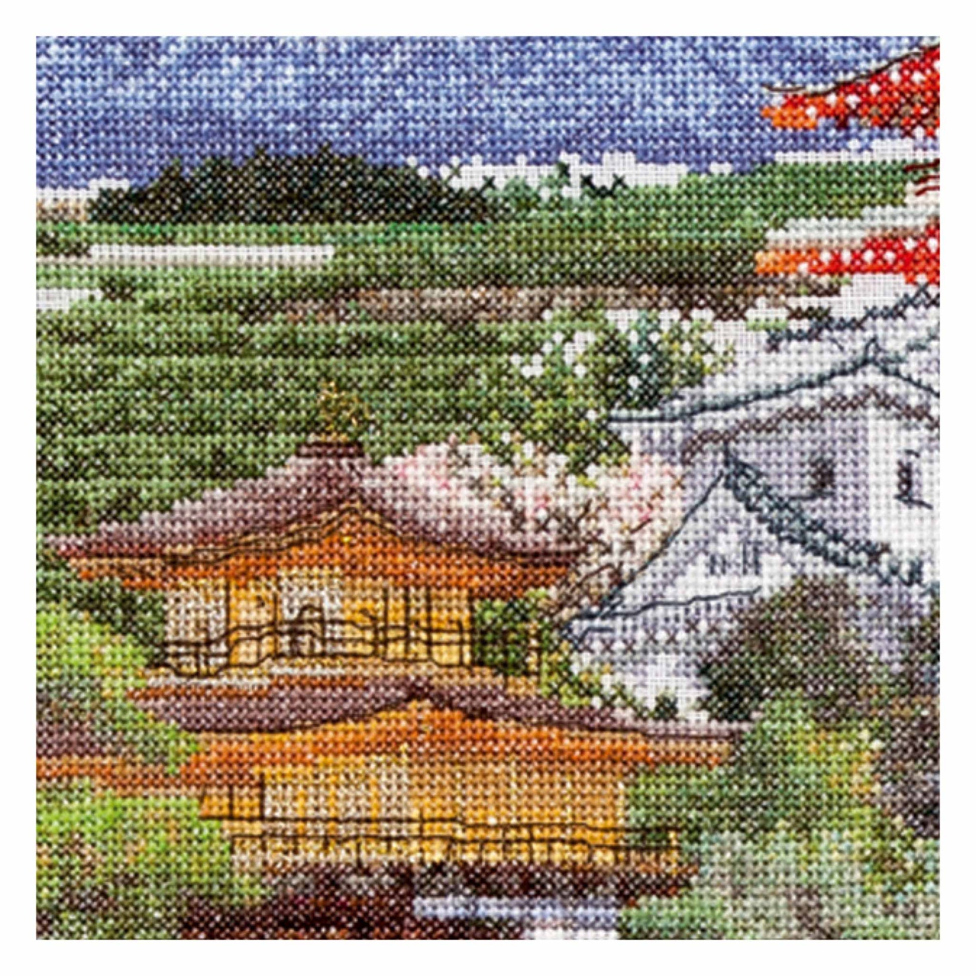 Cross-stitched landscape with a traditional house, cherry blossoms close up
