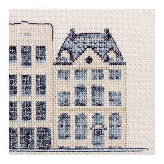Cross-stitched design of a building with blue windows on a white background