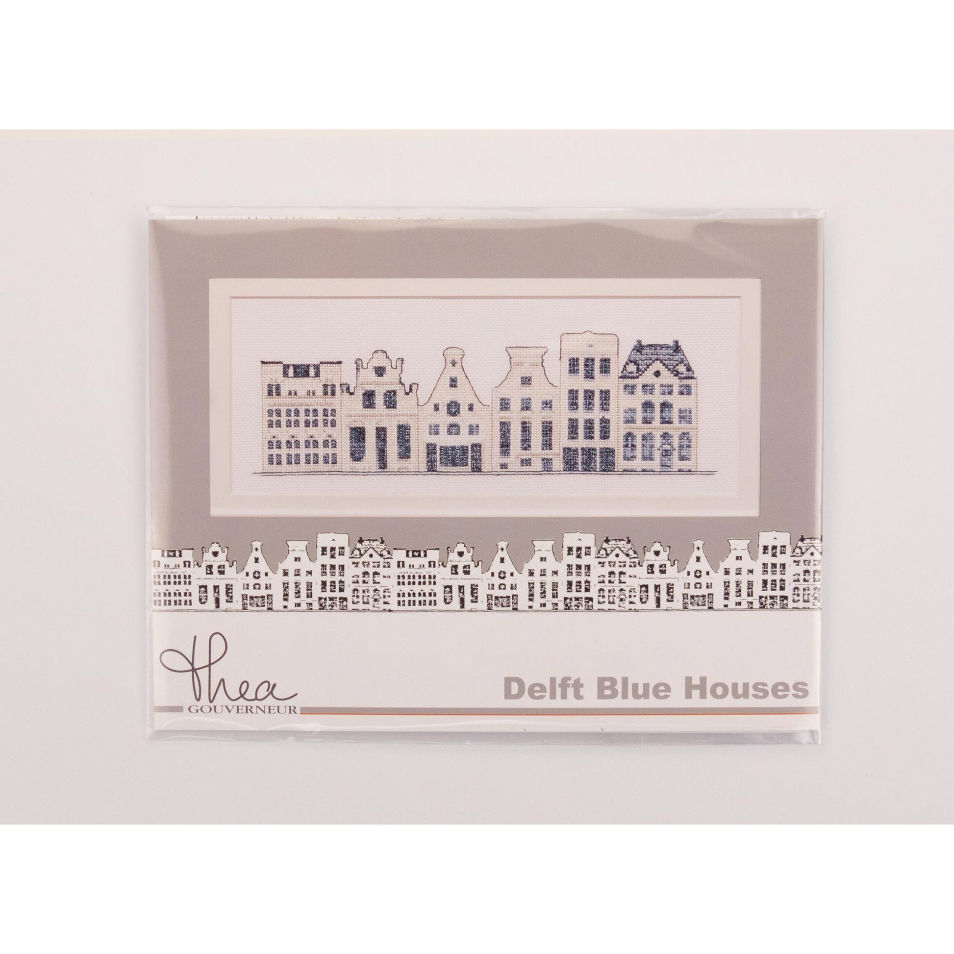 Framed embroidery of Delft blue houses with 'Thea Gouverneur' branding on a white background