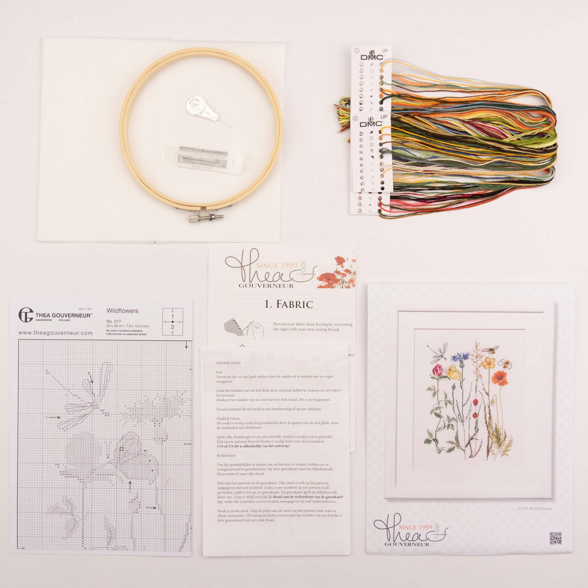 Embroidery kit with pattern sheet, fabric, instruction, hoop and threads on a white background