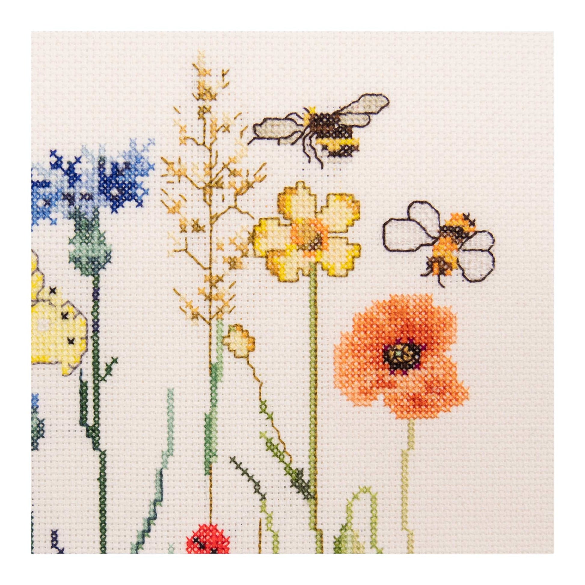 Cross stitch pattern of wildflowers and bees close up