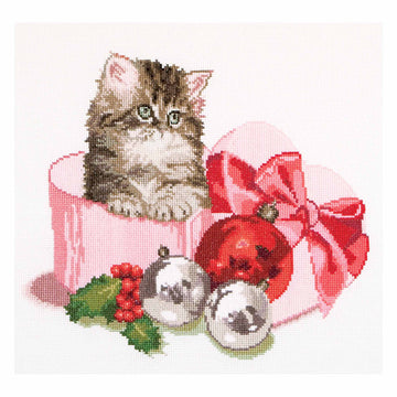 Cross-stitched design of a kitten in a pink box with Christmas ornaments on a white background