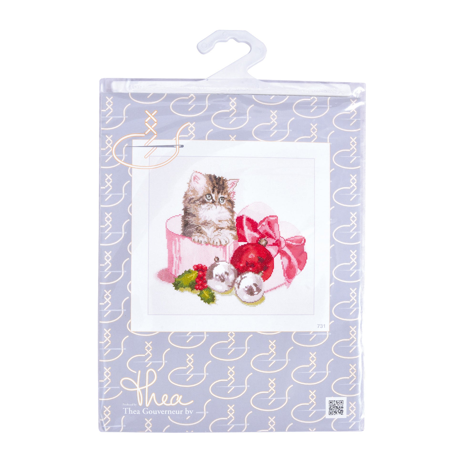 Packaged cross stitch kit with a cat illustration and Christmas decorations on a white background