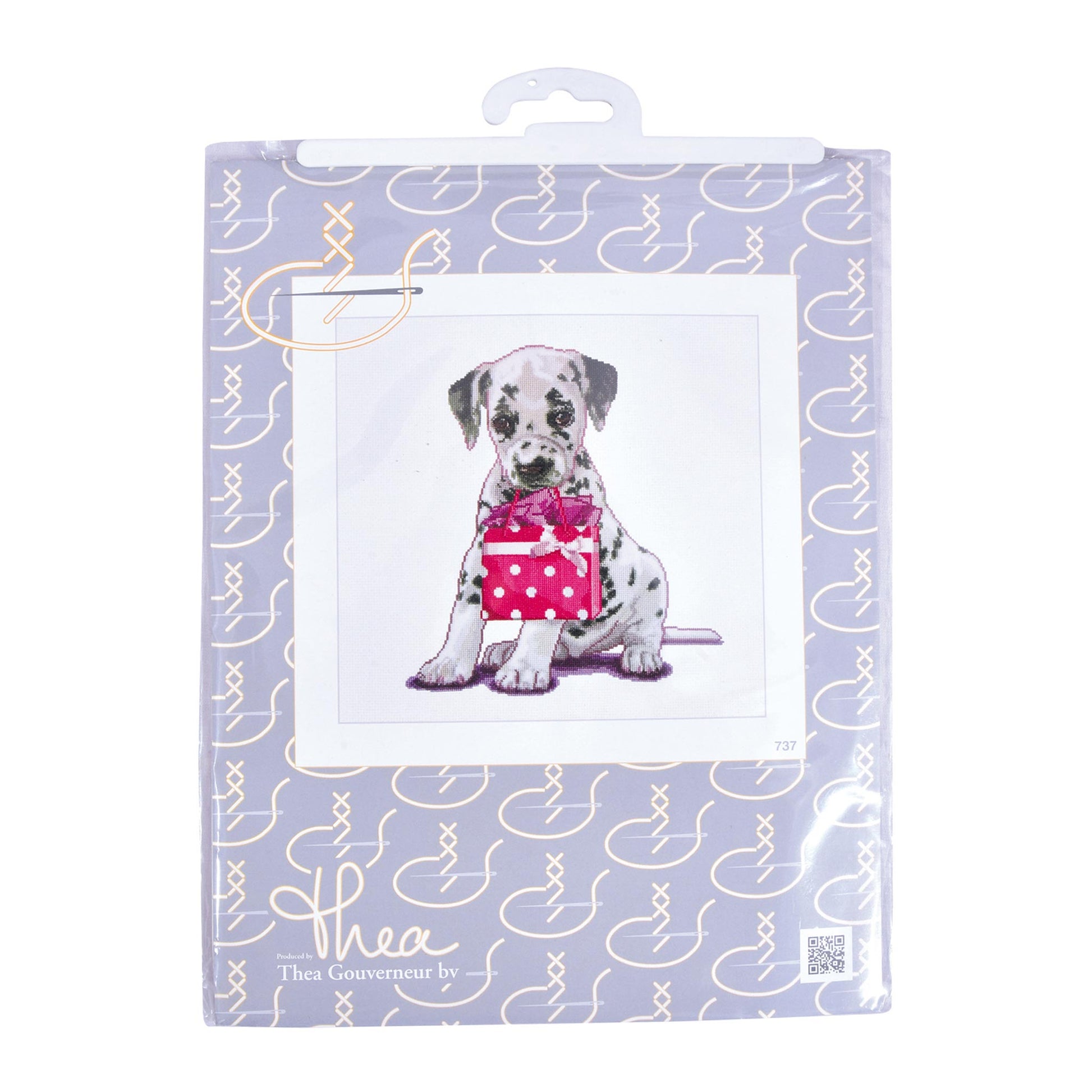 Cross stitch kit package with a Dalmatian dog holding a pink polka dot box on a light purple background.