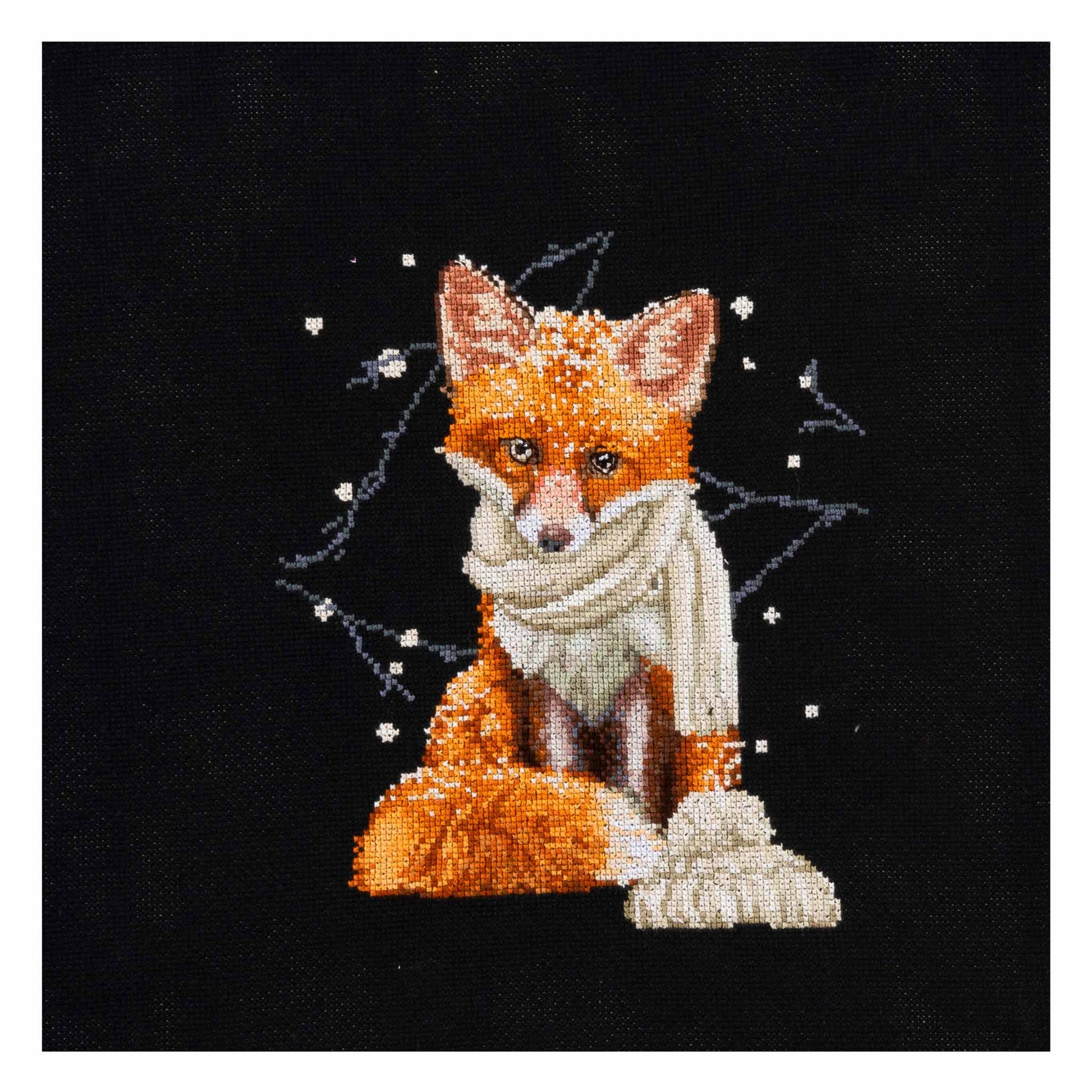 Cross-stitched fox wearing a scarf on black fabric