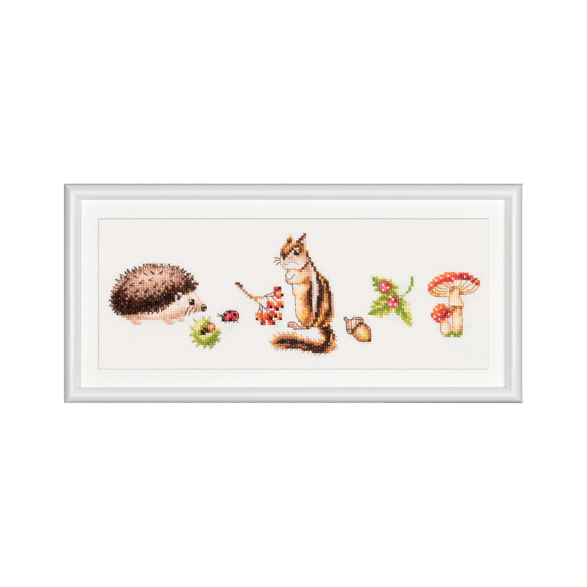 Framed cross-stitch art of a hedgehog, chipmunk, and mushrooms on a white background