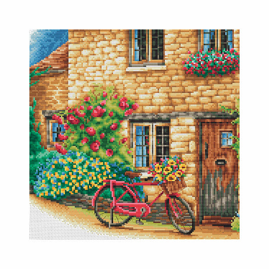 Cross stitch close up a charming house with a pink bicycle in front