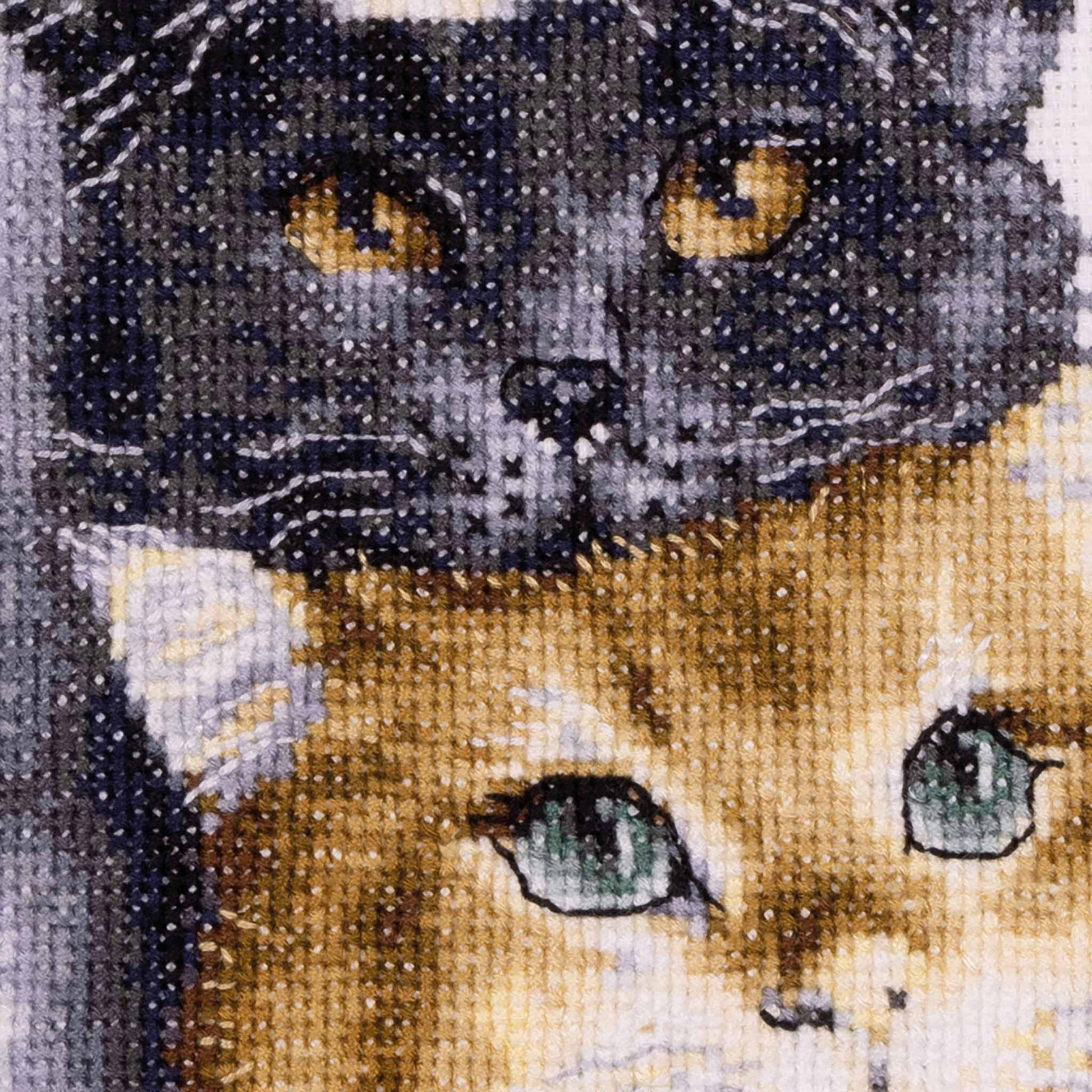 Cross-stitched design of a  black and ginger cat close up