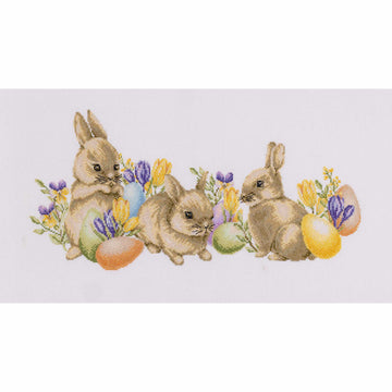 Cross-stitched design of three bunnies with Easter eggs and flowers on a white background
