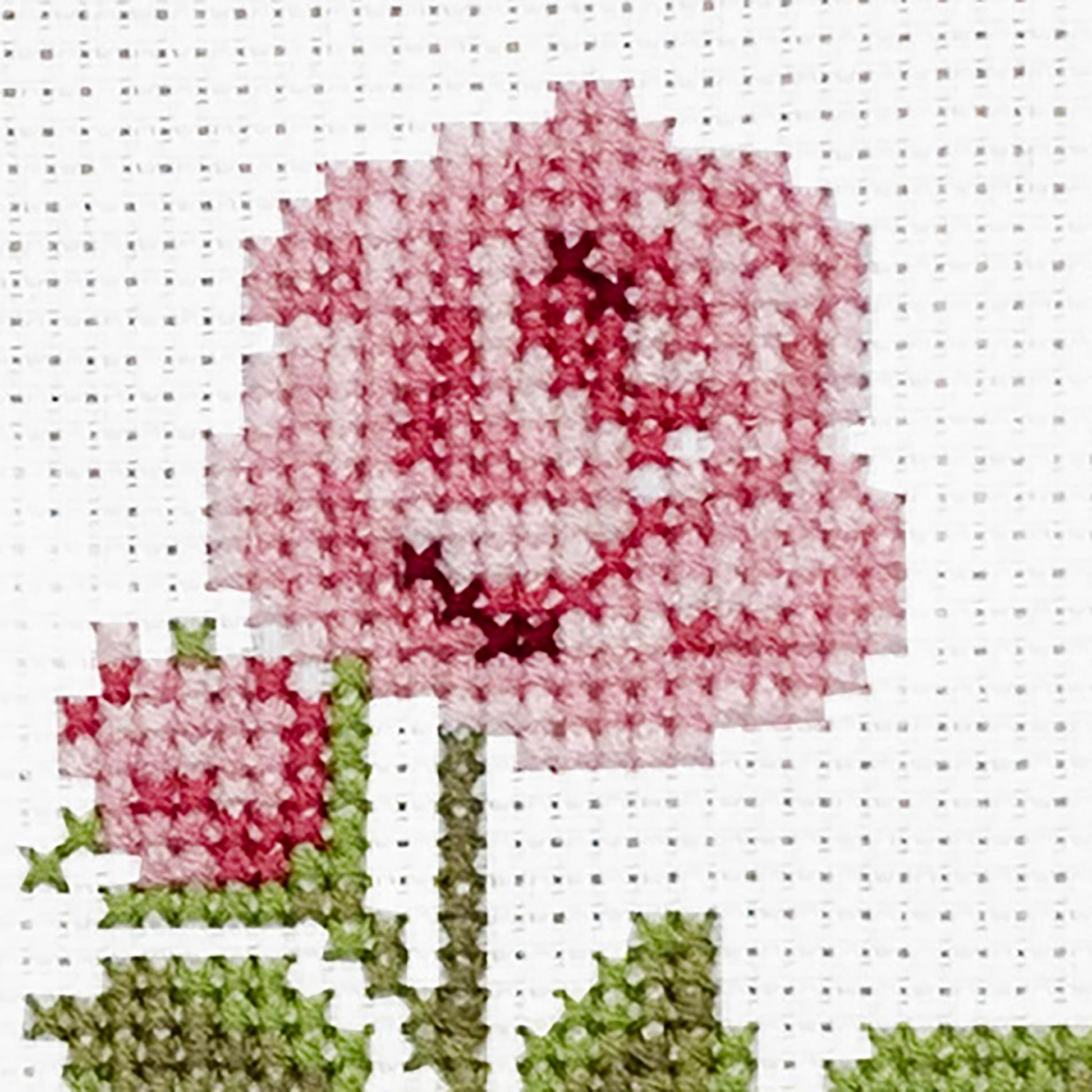 Cross-stitched pattern of a pink rose flower on a white background