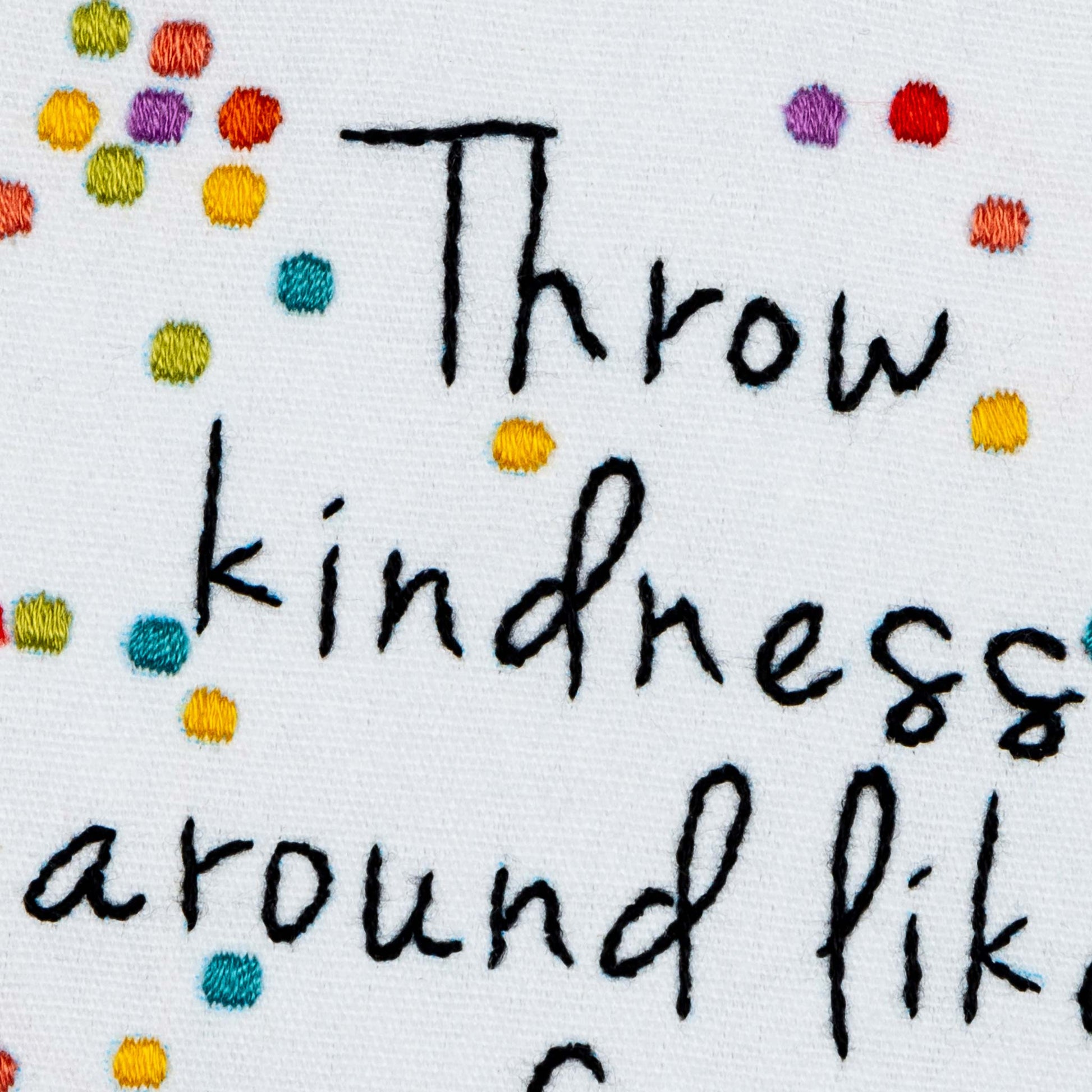 Embroidered Text 'Throw kindness around like a confetti' with colorful dots on a white background