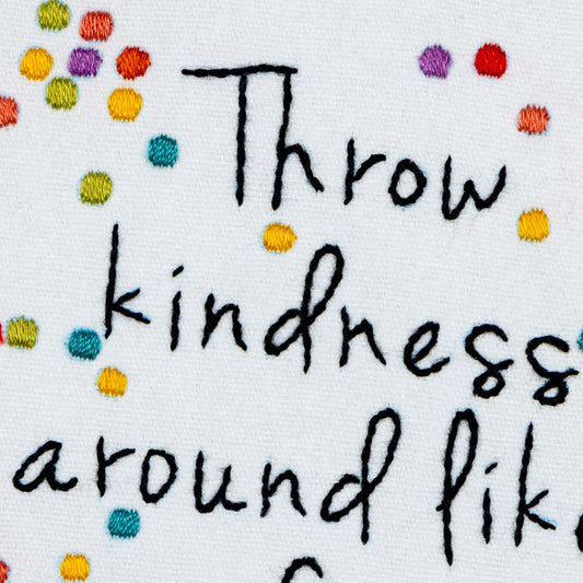 Embroidered Text 'Throw kindness around like a confetti' with colorful dots on a white background
