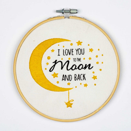 Embroidery on a hoop with 'I love you to the moon and back' text and yellow crescent moon design on a white background