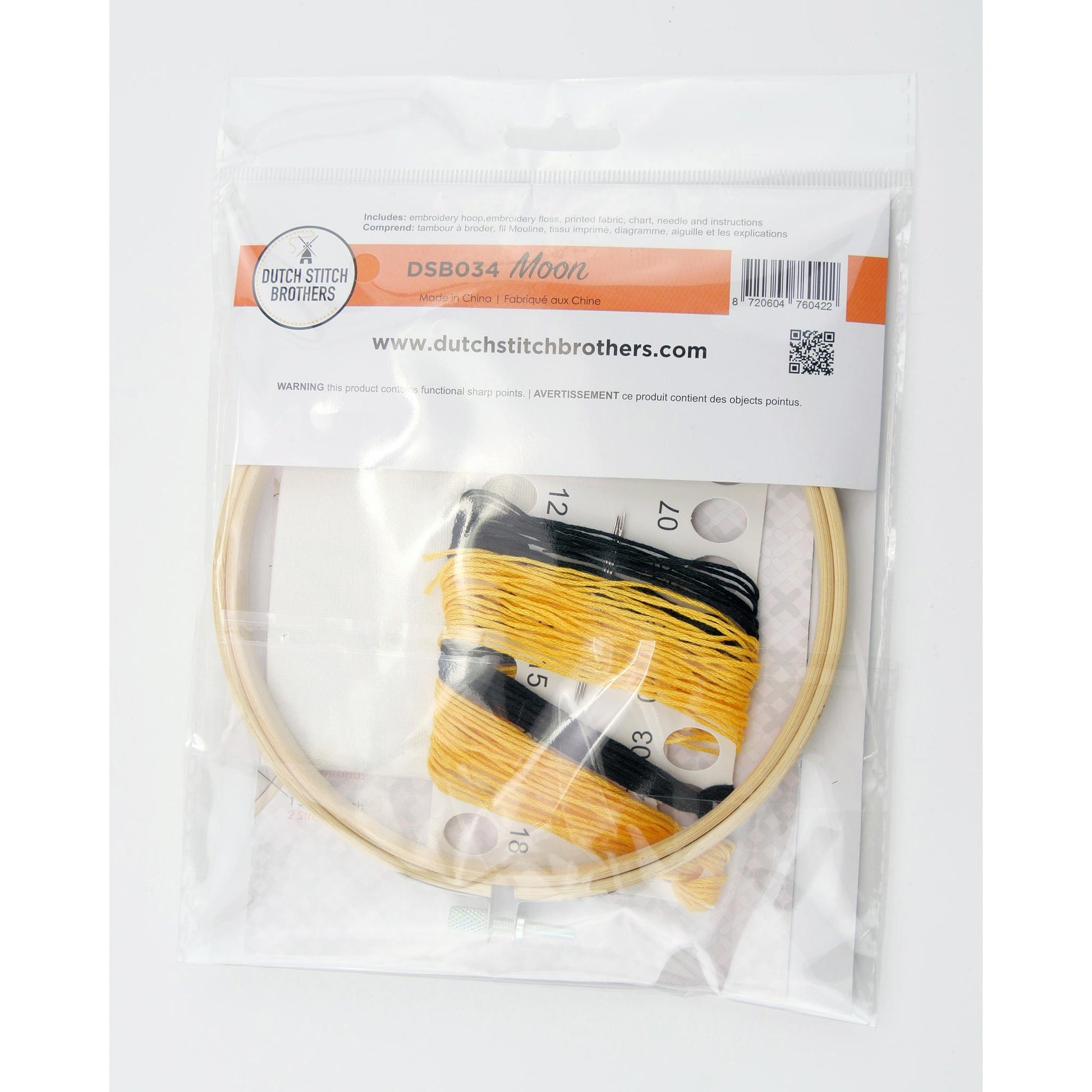 Embroidery kit with the hoop, colored threads and fabrics  inside a clear package on a white background