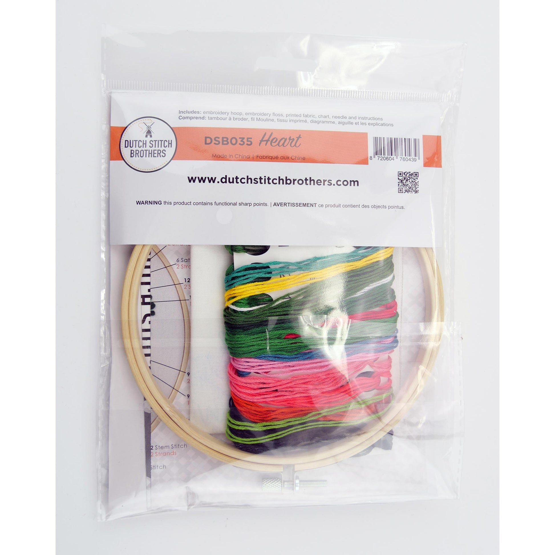 Embroidery kit including a hoop with colorful threads, needlework fabrics and packaging on a white background