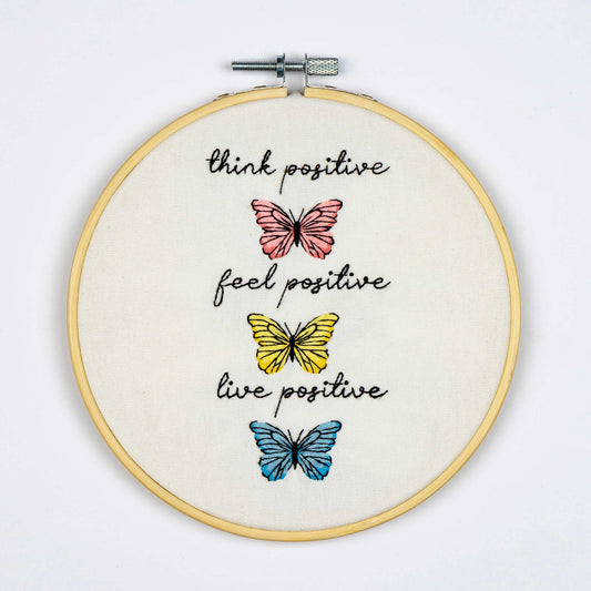 Embroidery on the Embroidery hoop with butterflies and motivational text on a white background