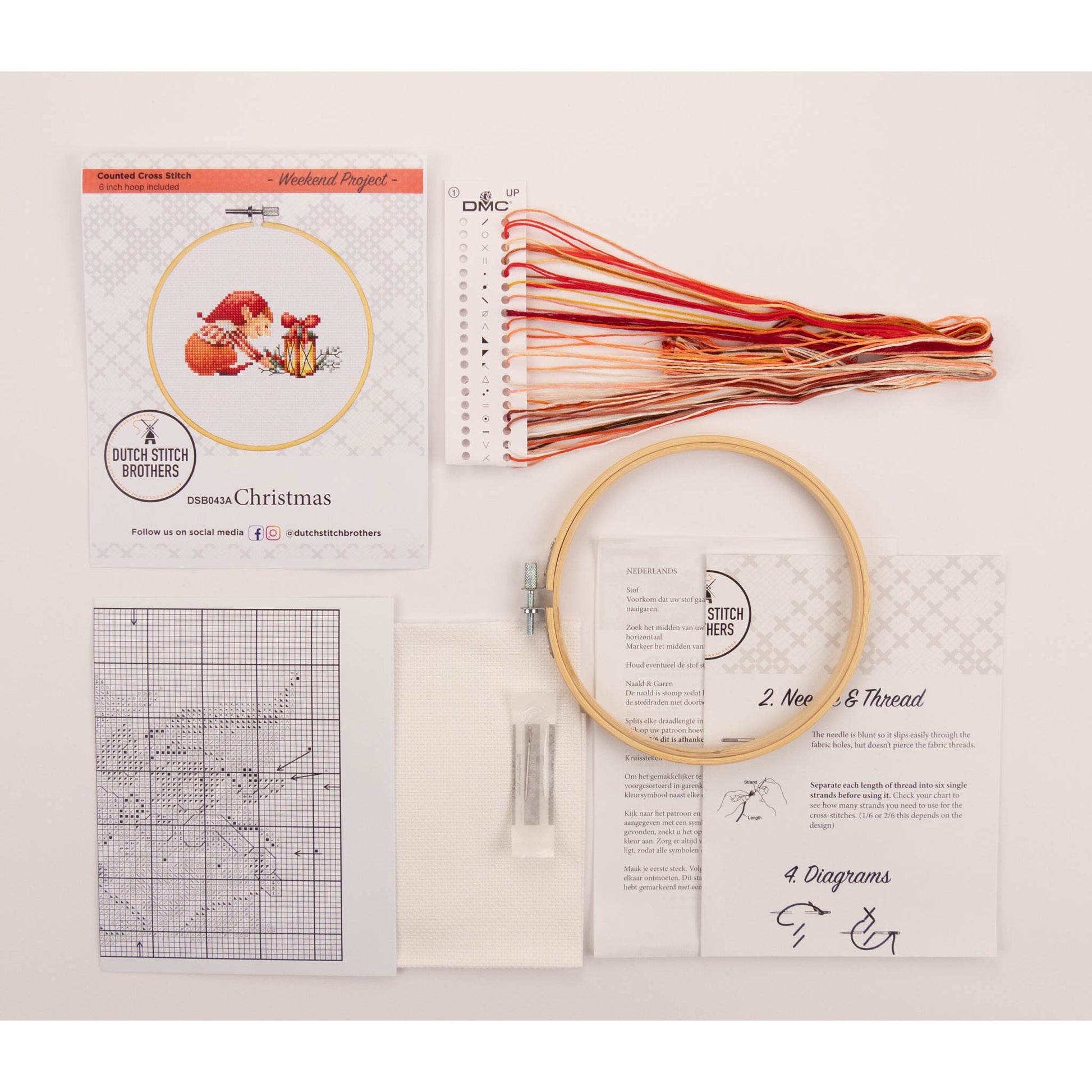 Cross stitch kit with embroidery hoop, presorted threads, and pattern chart on a white background