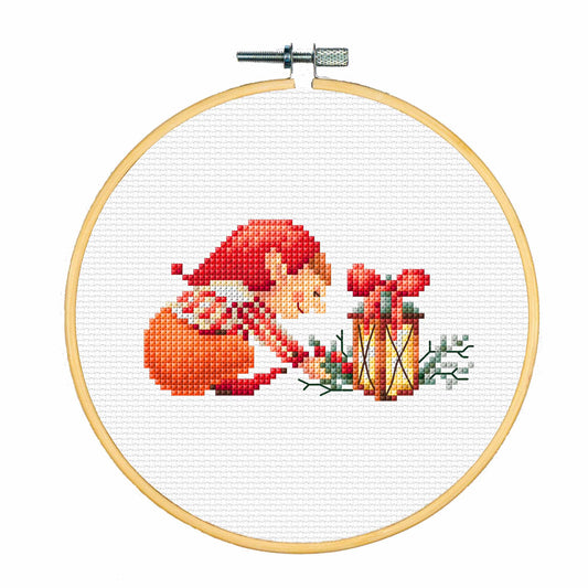 Cross-stitched design of an elf with a Christmas lantern in a wooden hoop on a white background