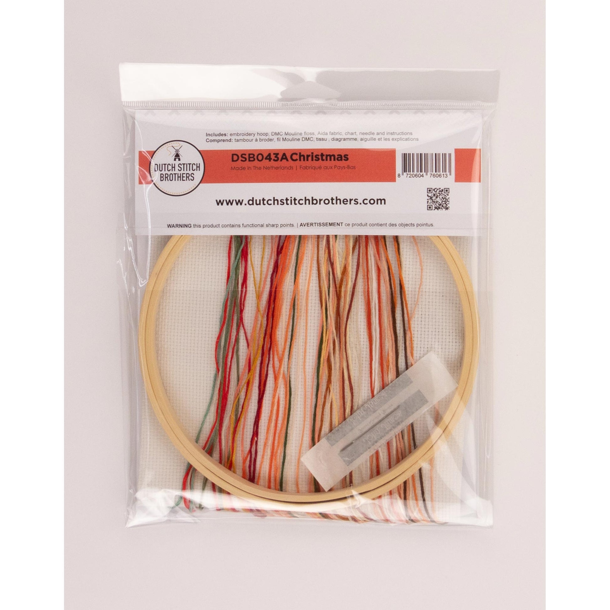 Embroidery hoop kit with Aida fabrics, colorful presorted threads and a needle in a clear package on a white background
